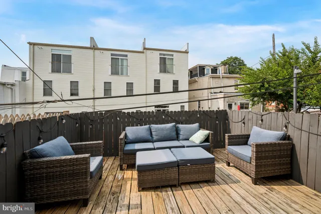 a roof deck with couches and wooden floor