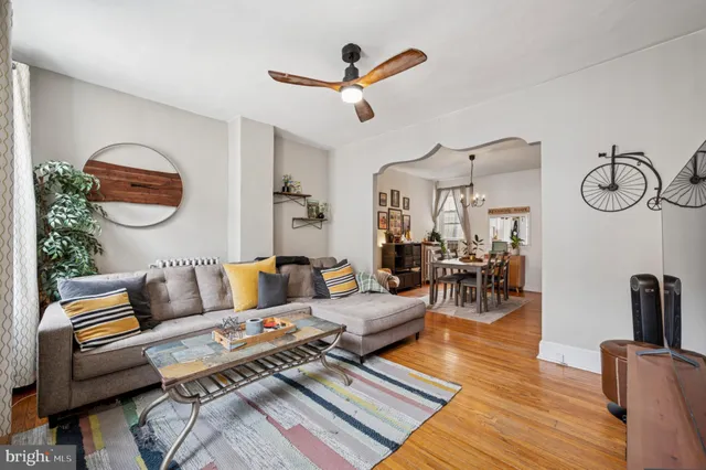 a living room with furniture a rug and wooden floor