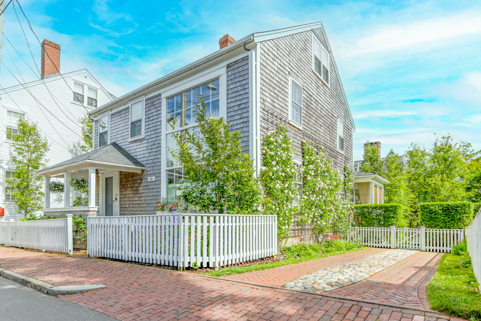 12 Hussey Street Nantucket, MA 02554 - Photo 1 of 47 a front view of a house with a garden