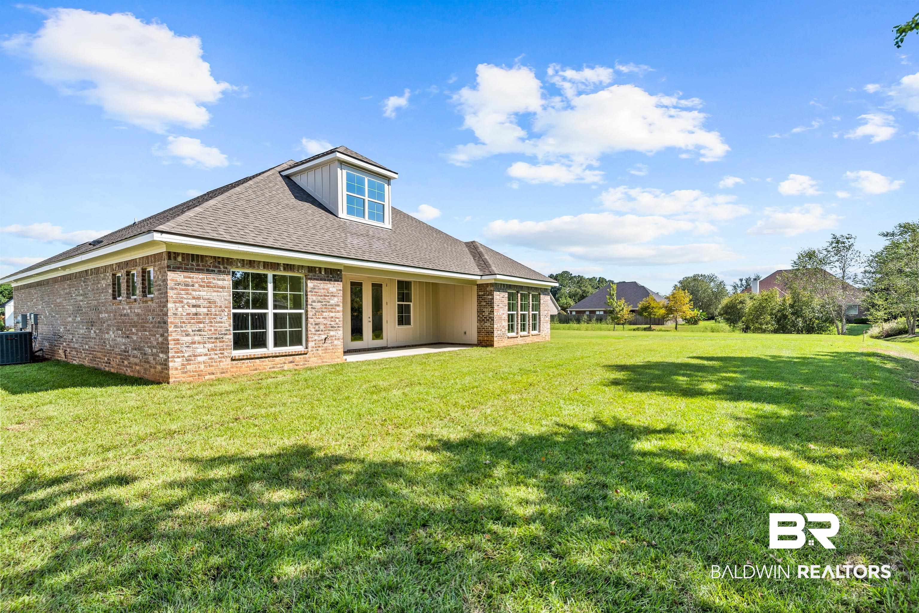 25927 Capra Court Daphne, AL 36526 - Photo 32 of 37 Rear view of house with a patio, central air condition unit, and a yard