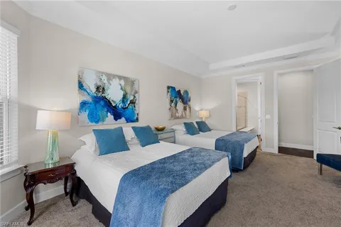 a bed room with two bed and windows