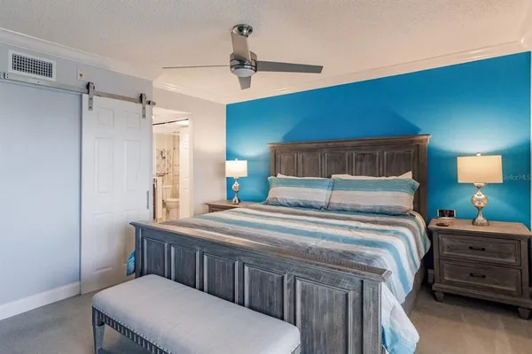 a bedroom with a bed a chandelier and a dresser