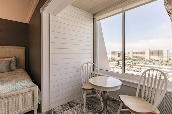 a view of a room that has a bed and a chair in it