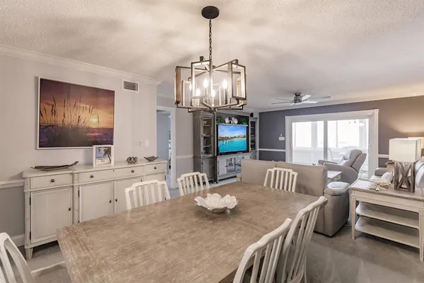 a living room with furniture chandelier and a flat screen tv