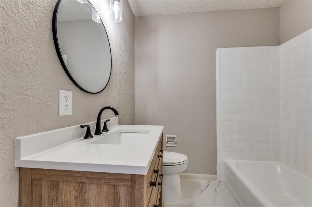 2320 Muret Street Irving, TX 75062 - Photo 11 of 12 a bathroom with a sink a toilet and a mirror