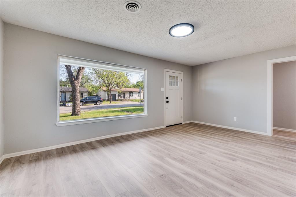 2320 Muret Street Irving, TX 75062 - Photo 2 of 12 an empty room with wooden floor and windows