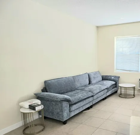 a living room with a couch and a potted plant