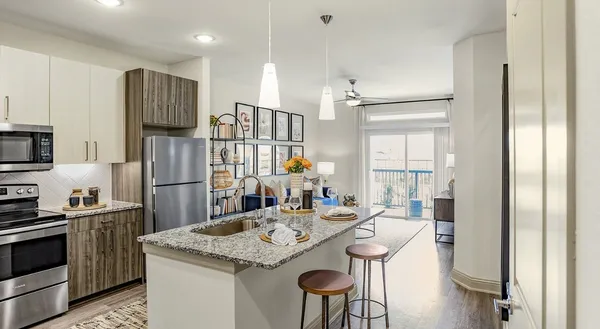 a kitchen with stainless steel appliances granite countertop a sink refrigerator and microwave