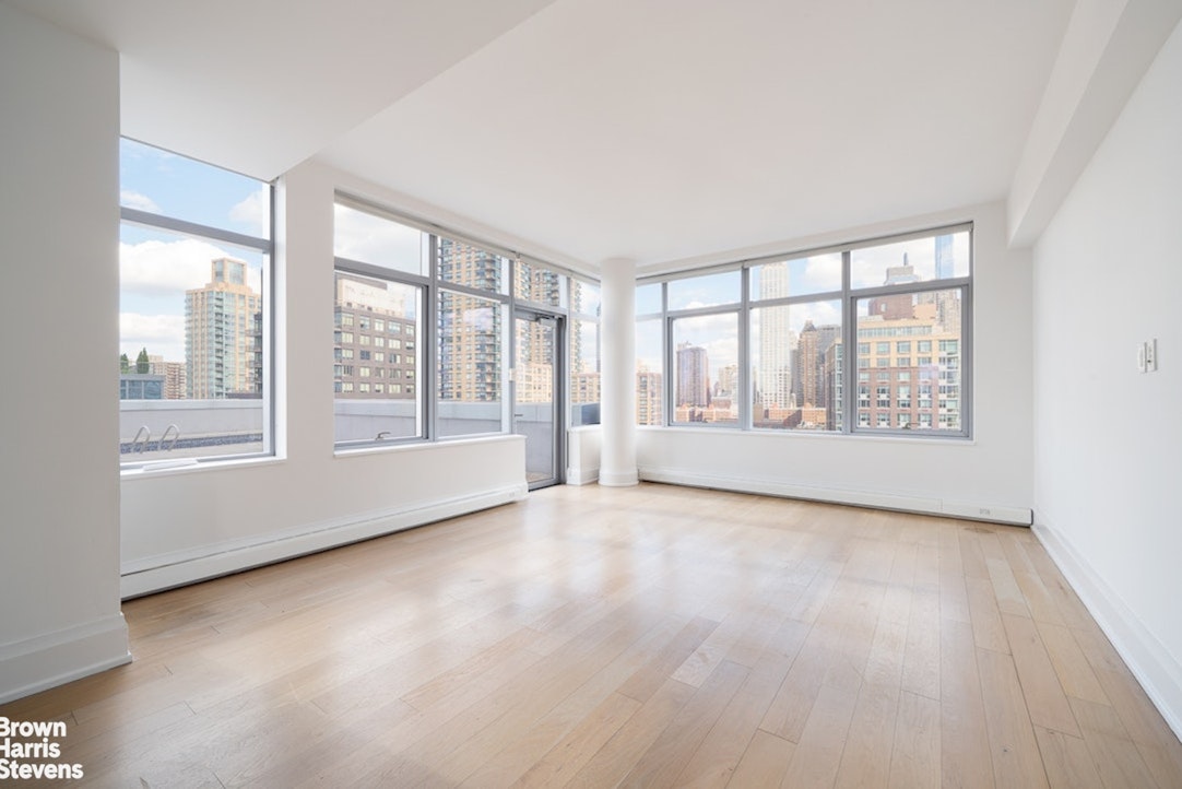 50 Riverside Boulevard, Unit 21A Manhattan, NY 10069 - Photo 8 of 11 an empty room with wooden floor and windows
