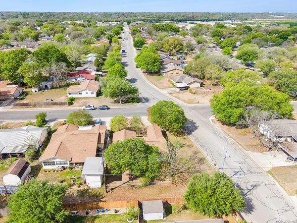 an aerial view of residential houses with outdoor space and street view