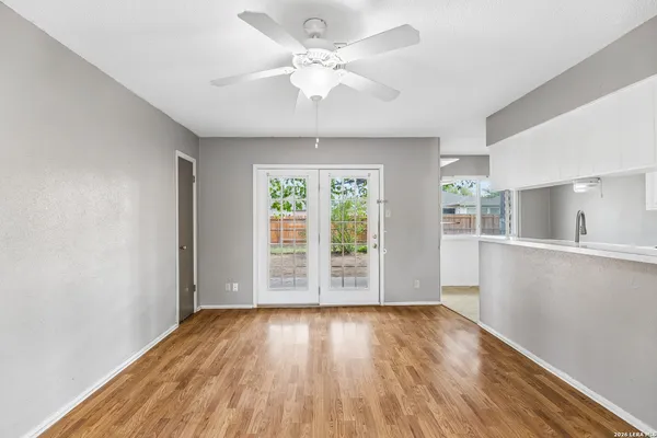 an empty room with wooden floor and windows