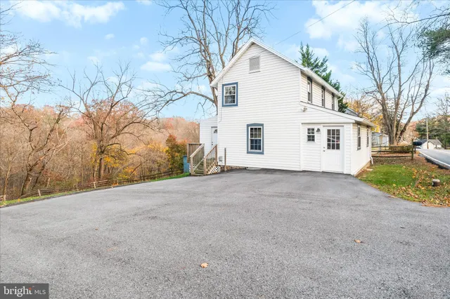 a view of a white house with a yard and garage