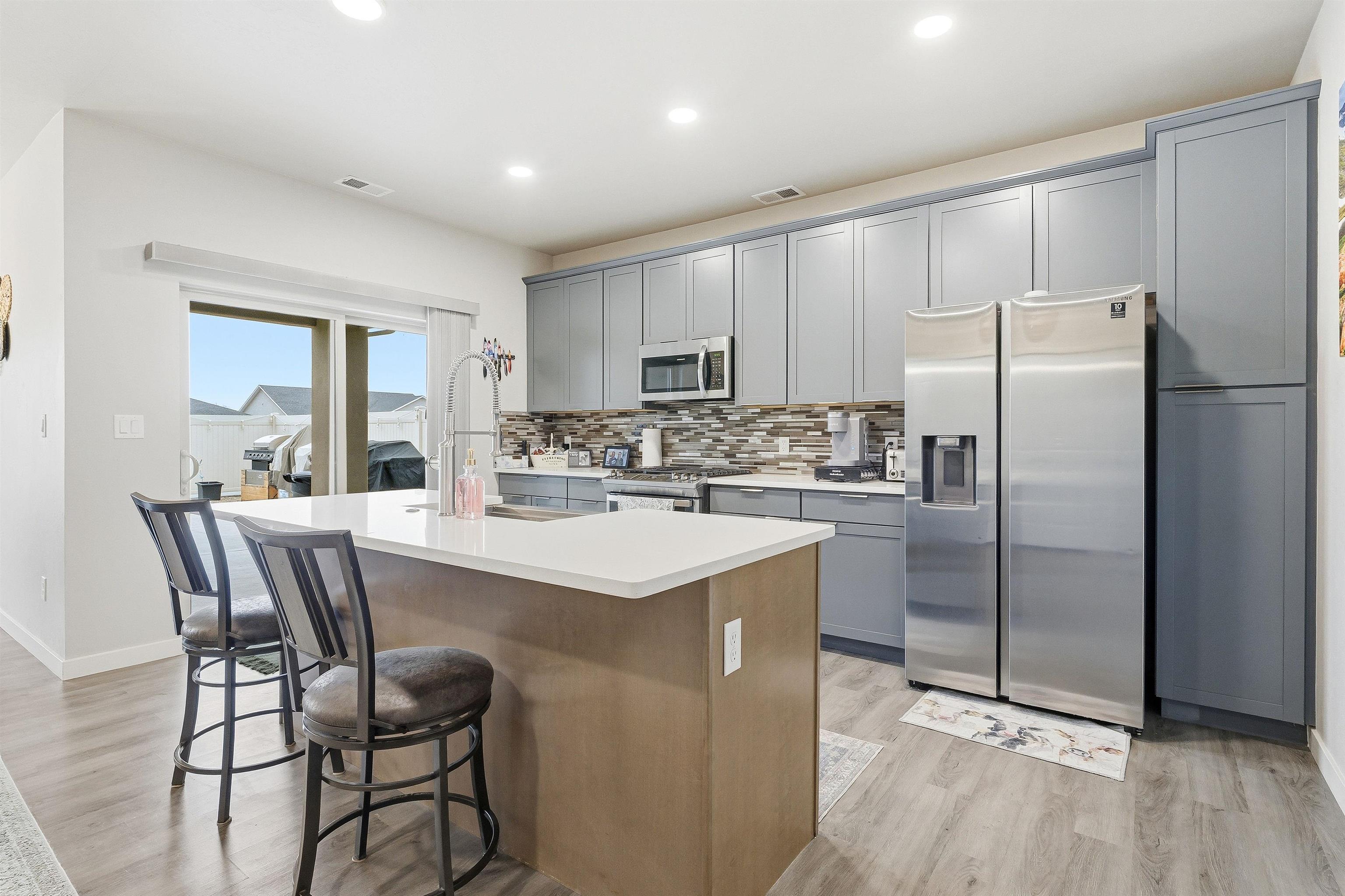 623 Thunder Ridge Drive Grand Junction, CO 81504 - Photo 19 of 40 a kitchen with kitchen island a refrigerator a stove a dining table and chairs