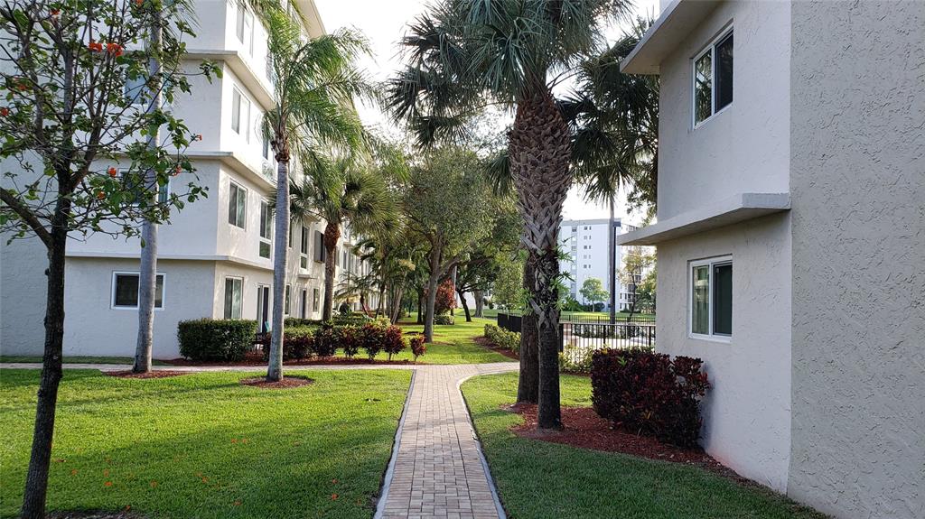 2216 North Cypress Bend Drive, Unit 504 Pompano Beach, FL 33069 - Photo 20 of 33 a front view of a house with a yard