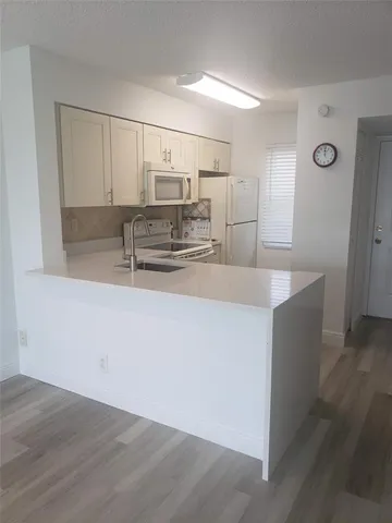a kitchen with kitchen island white cabinets and stainless steel appliances