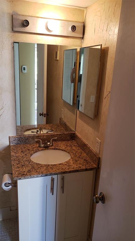 2216 North Cypress Bend Drive, Unit 504 Pompano Beach, FL 33069 - Photo 5 of 33 a bathroom with a granite countertop sink and a mirror
