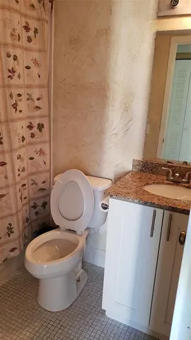 a bathroom with a toilet a sink and a mirror