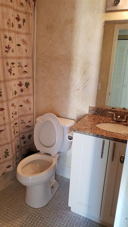 2216 North Cypress Bend Drive, Unit 504 Pompano Beach, FL 33069 - Photo 6 of 33 a bathroom with a toilet a sink and a mirror