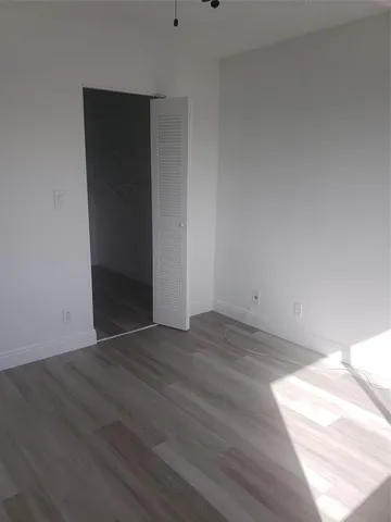 an empty room with wooden floor and closet