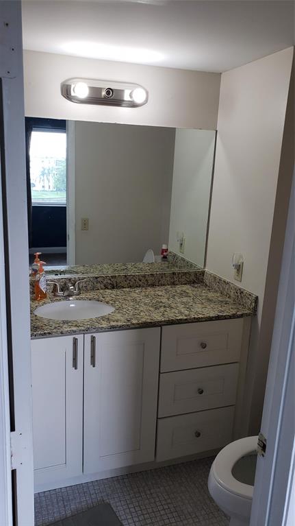 2216 North Cypress Bend Drive, Unit 504 Pompano Beach, FL 33069 - Photo 10 of 33 a bathroom with a granite countertop sink and a mirror