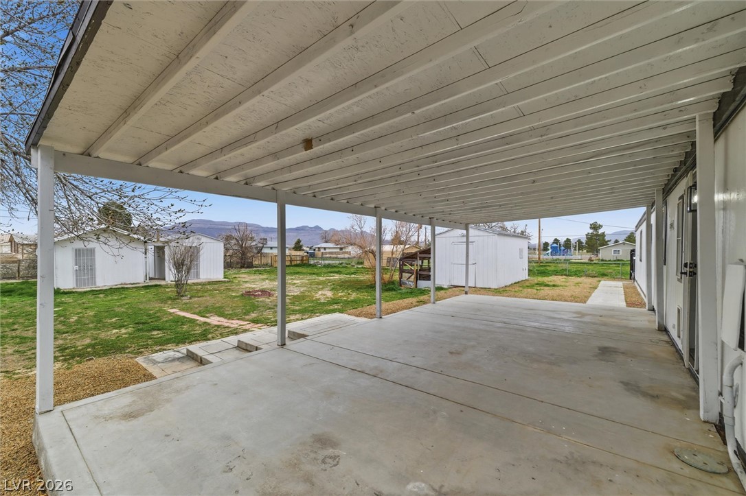 3940 Point Drive Pahrump, NV 89060 - Photo 30 of 35 A spacious covered patio invites outdoor relaxation, overlooking a private yard with storage sheds.