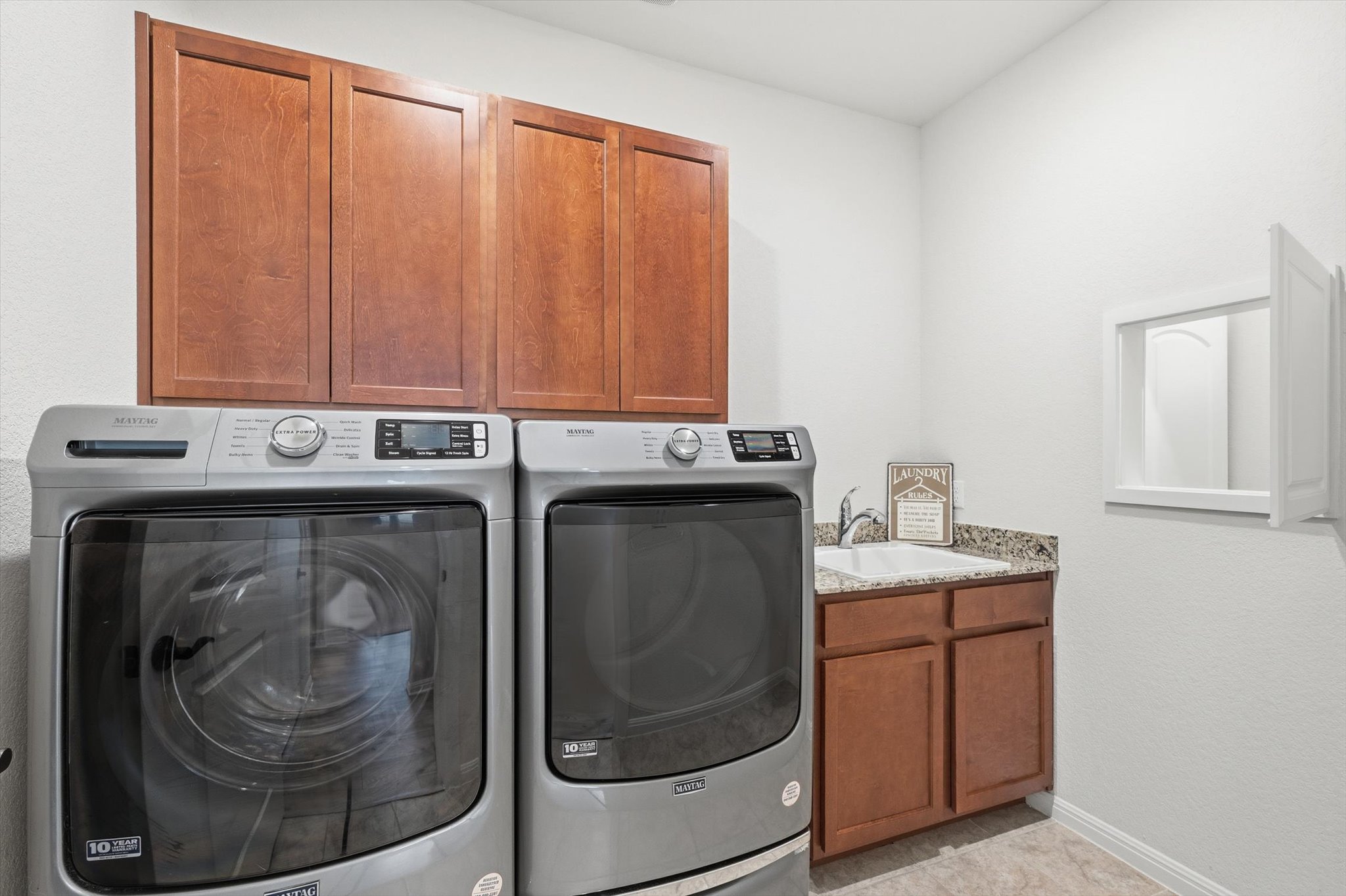113 Lafayette Street Georgetown, TX 78633 - Photo 16 of 39 Laundry Area with wood cabinetry and sink. Pass-through window to Primary Bath.