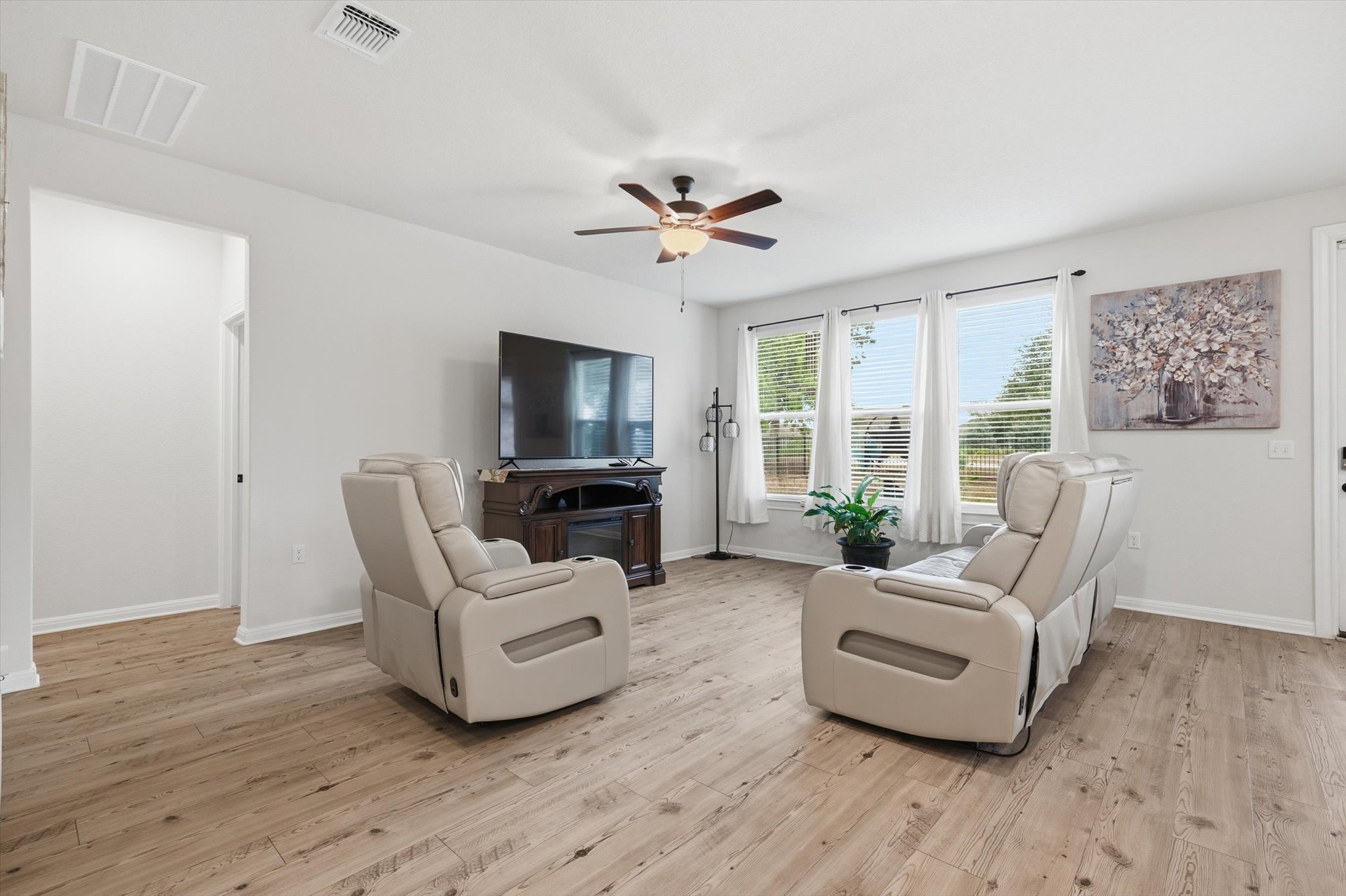113 Lafayette Street Georgetown, TX 78633 - Photo 21 of 39 Bright living space featuring wood-finish flooring, a ceiling fan, and multiple windows with blinds