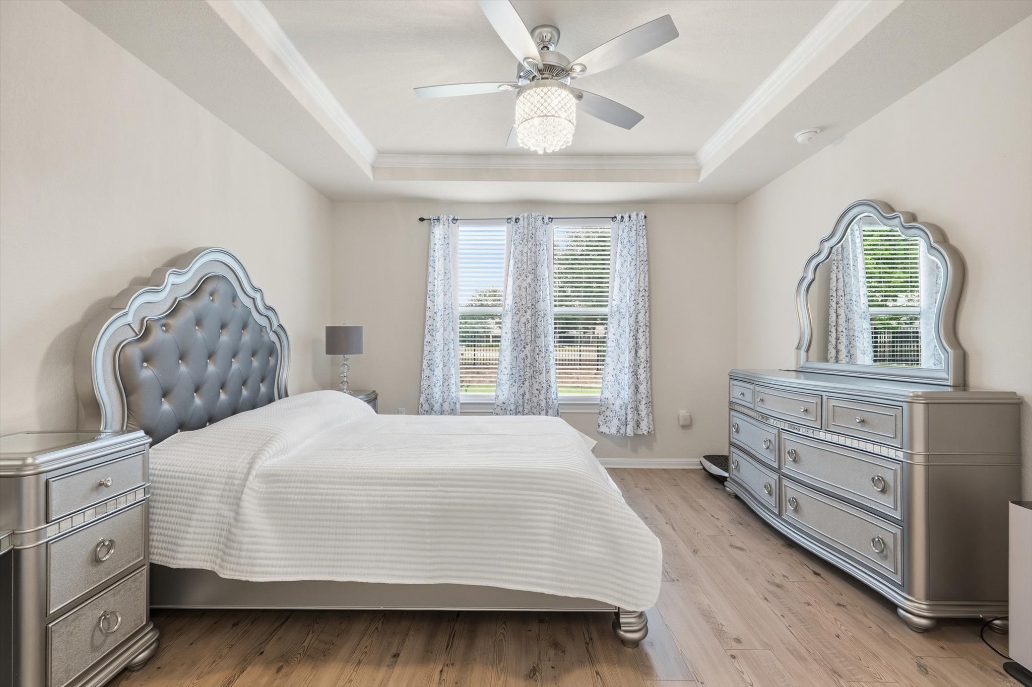 113 Lafayette Street Georgetown, TX 78633 - Photo 24 of 39 Bedroom featuring wood-finish flooring, tray ceiling, and a ceiling fan with integrated lighting