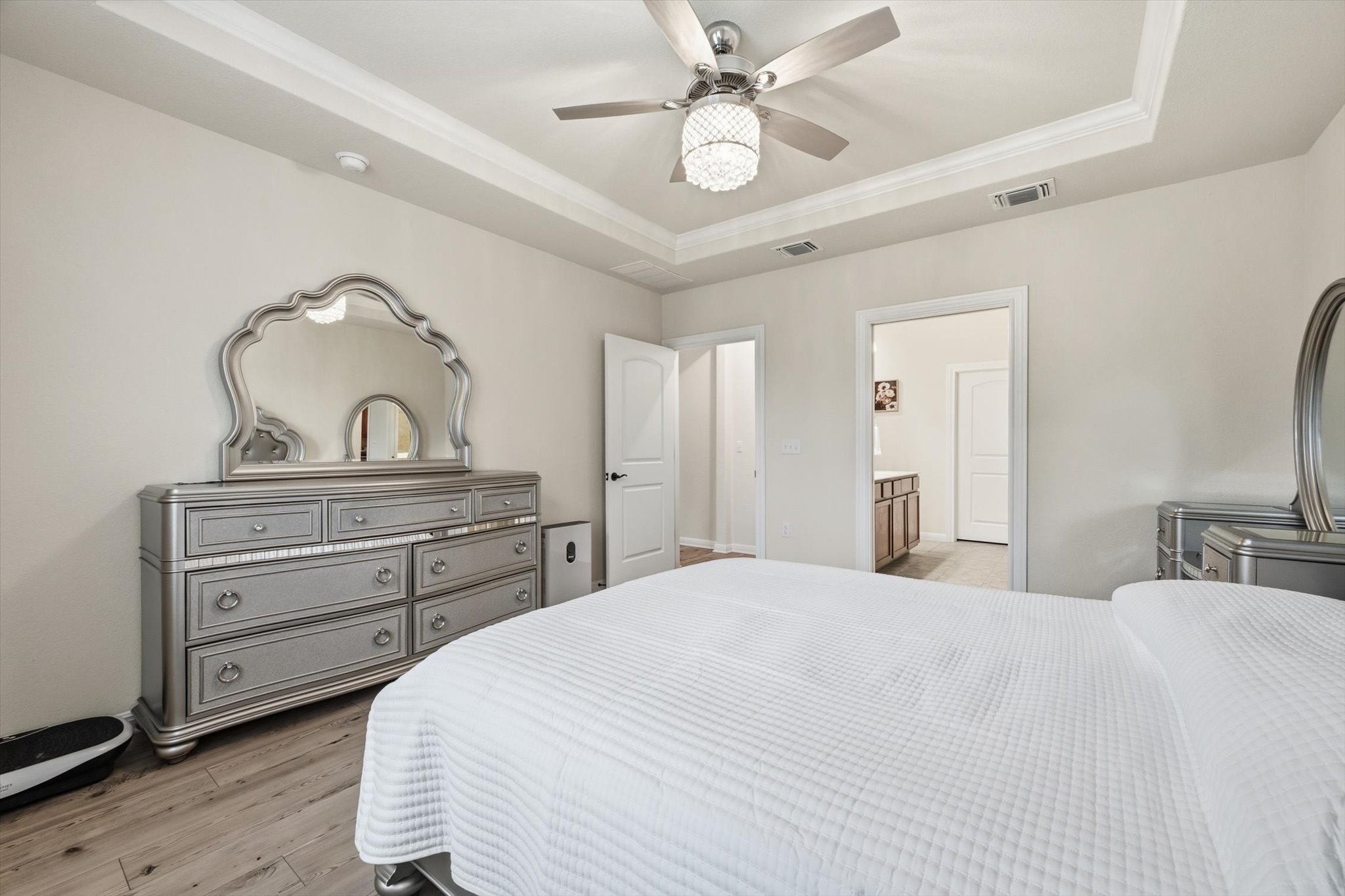 113 Lafayette Street Georgetown, TX 78633 - Photo 26 of 39 Bedroom featuring wood-finish flooring, a tray ceiling with crown molding, and a ceiling fan with integrated lighting
