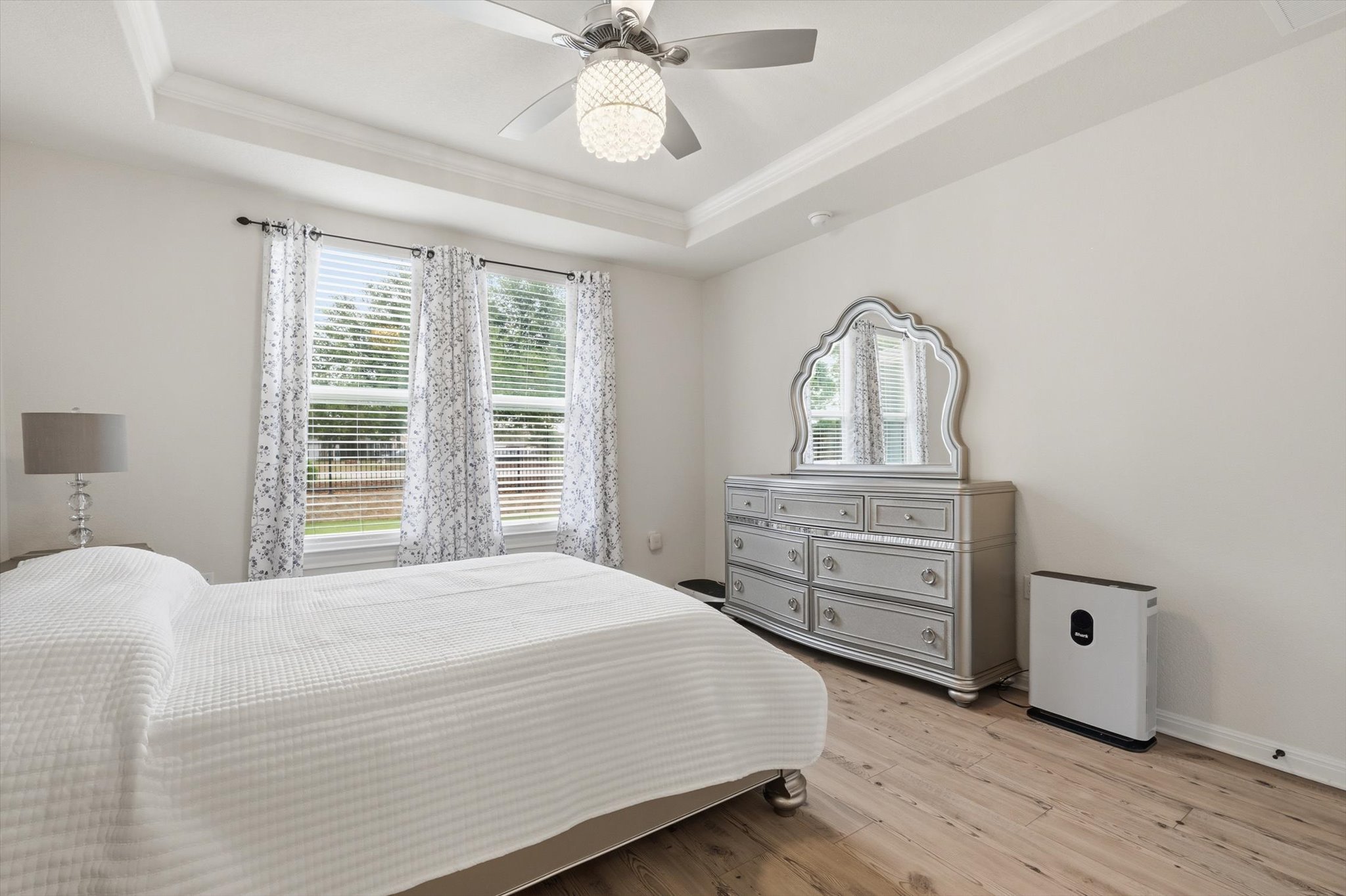 113 Lafayette Street Georgetown, TX 78633 - Photo 27 of 39 Bedroom featuring wood-finish flooring, a tray ceiling with crown molding, and a ceiling fan with integrated lighting