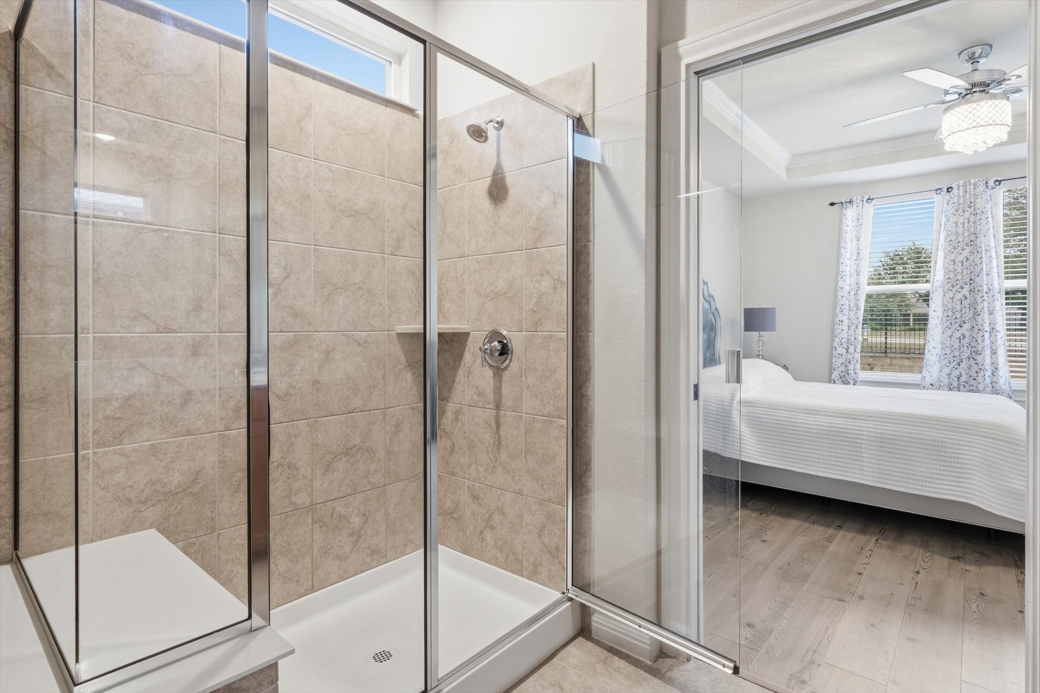 113 Lafayette Street Georgetown, TX 78633 - Photo 28 of 39 Spacious walk-in shower with floor-to-ceiling tile, integrated shelving, and a built-in bench