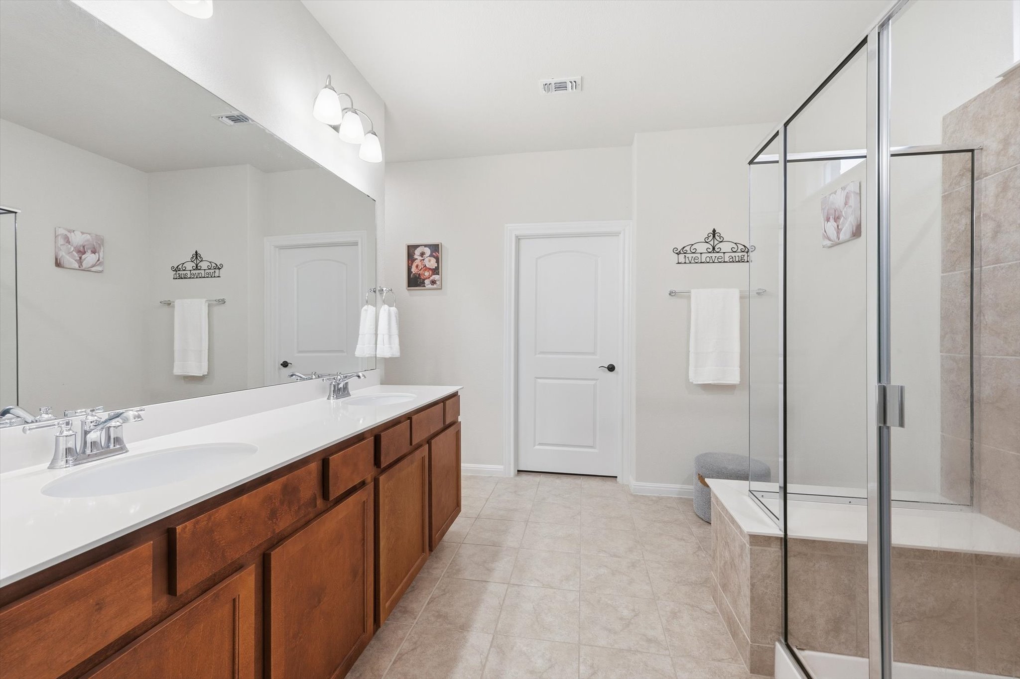 113 Lafayette Street Georgetown, TX 78633 - Photo 29 of 39 Spacious bathroom featuring a dual vanity with wood cabinetry, a large mirror, a separate glass-enclosed shower, and neutral-toned tile flooring