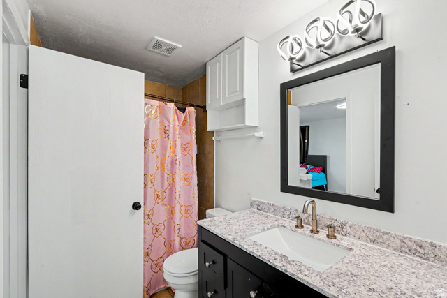 3689 Lasso Loop Circle Magna, UT 84044 - Photo 11 of 26 Bathroom featuring a vanity with dark cabinetry, integrated sink, and light speckled countertop