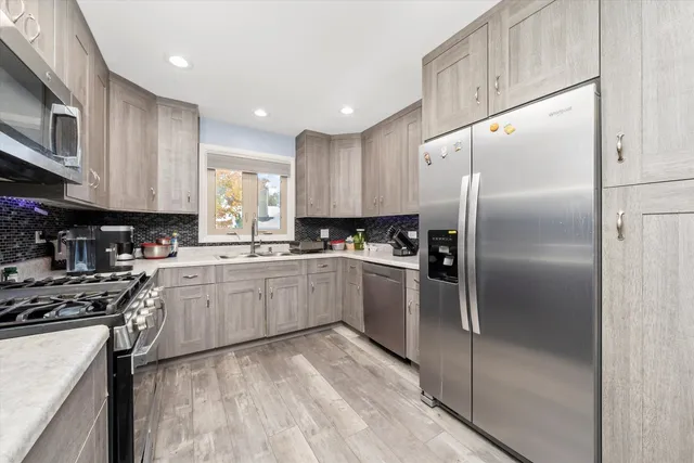a kitchen with a refrigerator a sink and white cabinets