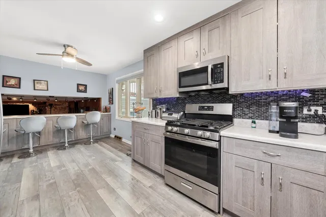 a kitchen with stainless steel appliances granite countertop a stove a sink and a microwave