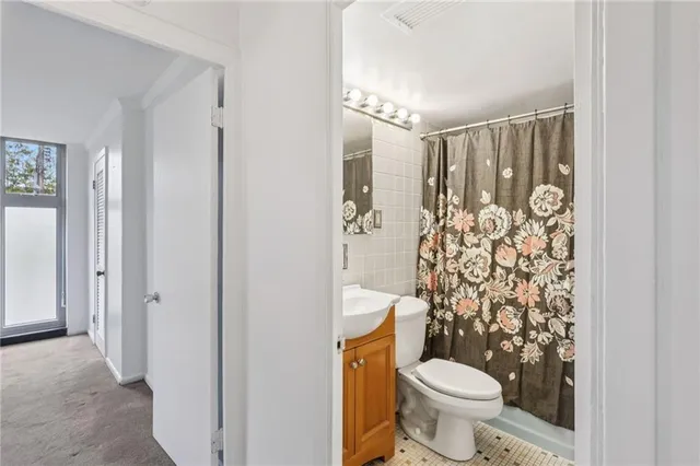 a bathroom with a toilet and shower curtain