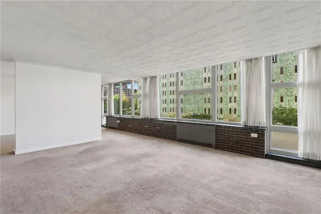 an empty room with windows and view of balcony
