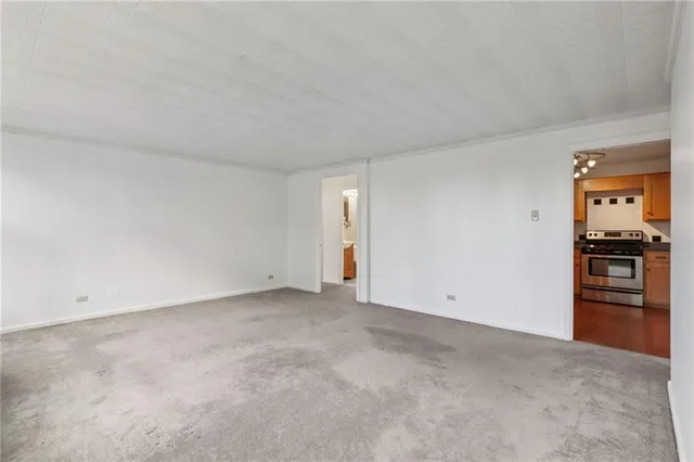 a view of a livingroom with a chandelier fan and windows