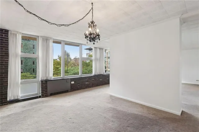 an empty room with chandelier and windows
