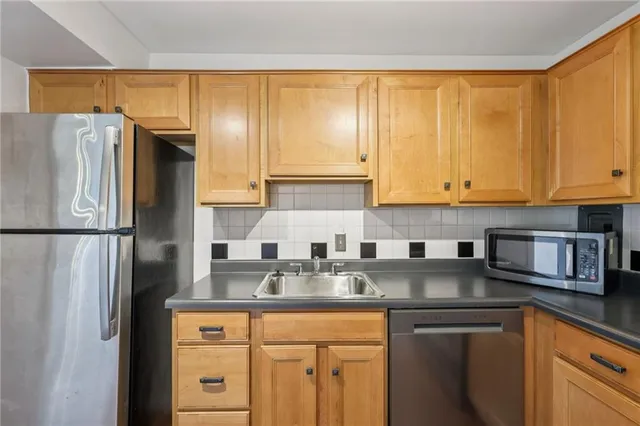 a kitchen with stainless steel appliances granite countertop a refrigerator and a sink
