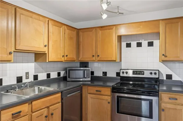 a kitchen with stainless steel appliances granite countertop a sink stove and refrigerator