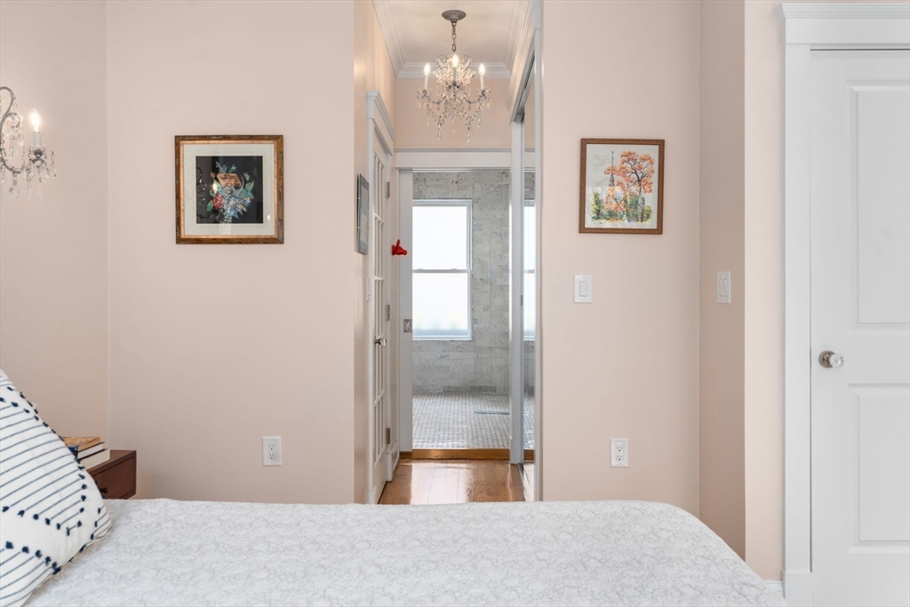 17 Walker Street Boston, MA 02129 - Photo 11 of 24 a bedroom with a bed and a chandelier