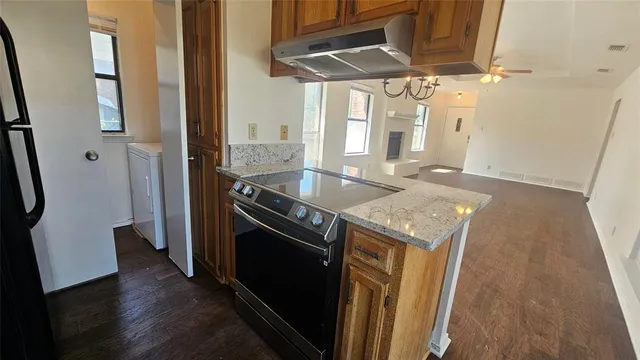 a kitchen with stainless steel appliances granite countertop a sink and a refrigerator