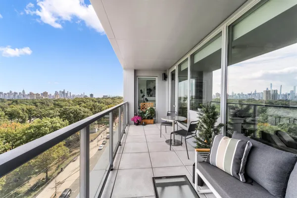 a balcony with furniture and a potted plant