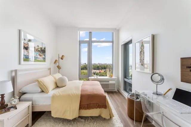 a spacious bedroom with a bed and a large window