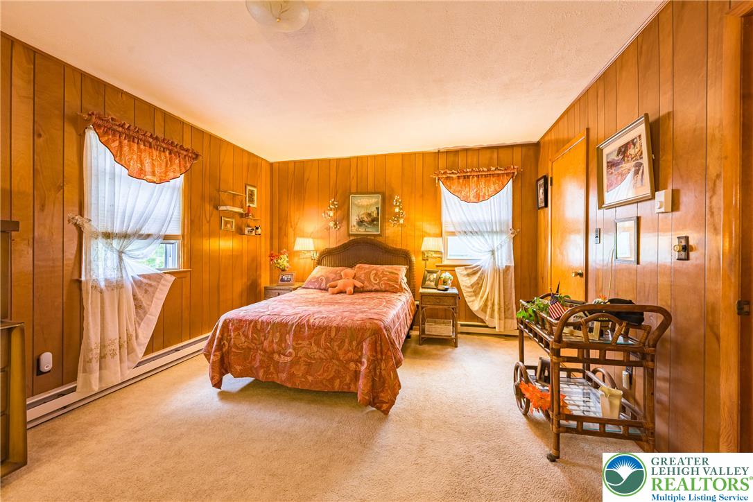 678 Interchange Road Kresgeville, PA 18333 - Photo 26 of 45 A restful bedroom features warm wood paneling and soft carpeting, offering a cozy retreat.