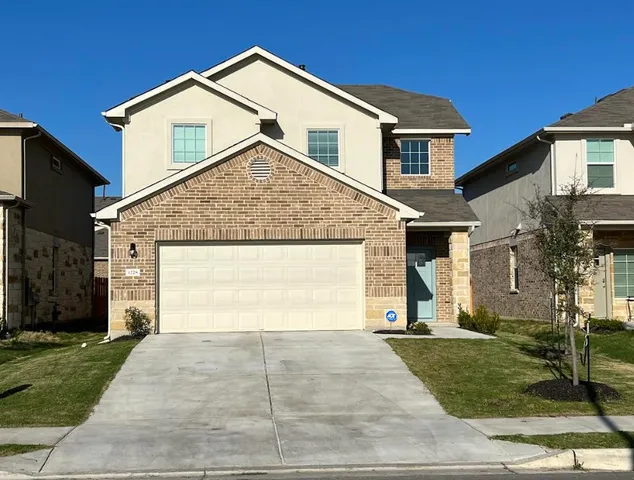 a front view of a house with a yard and garage