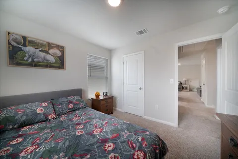 a bedroom with a bed and painting on the wall