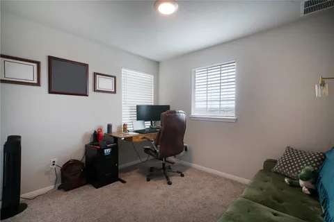 a view of a workspace with furniture and a window