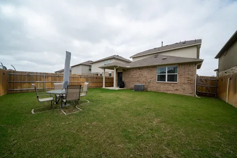 a backyard of a house with table and chairs